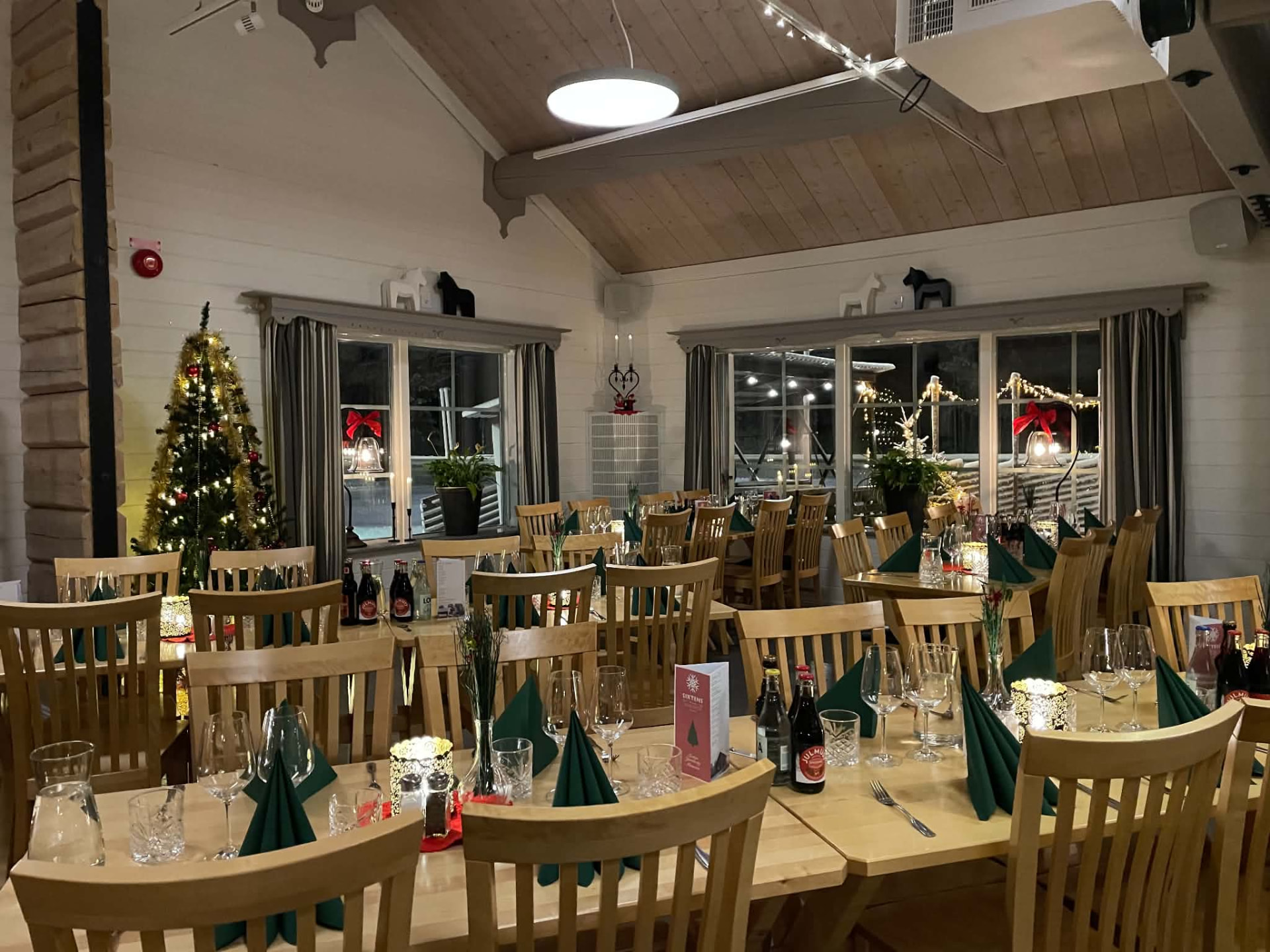 Julpyntad matsal med gran och dukade bord på Restaurang Sixten