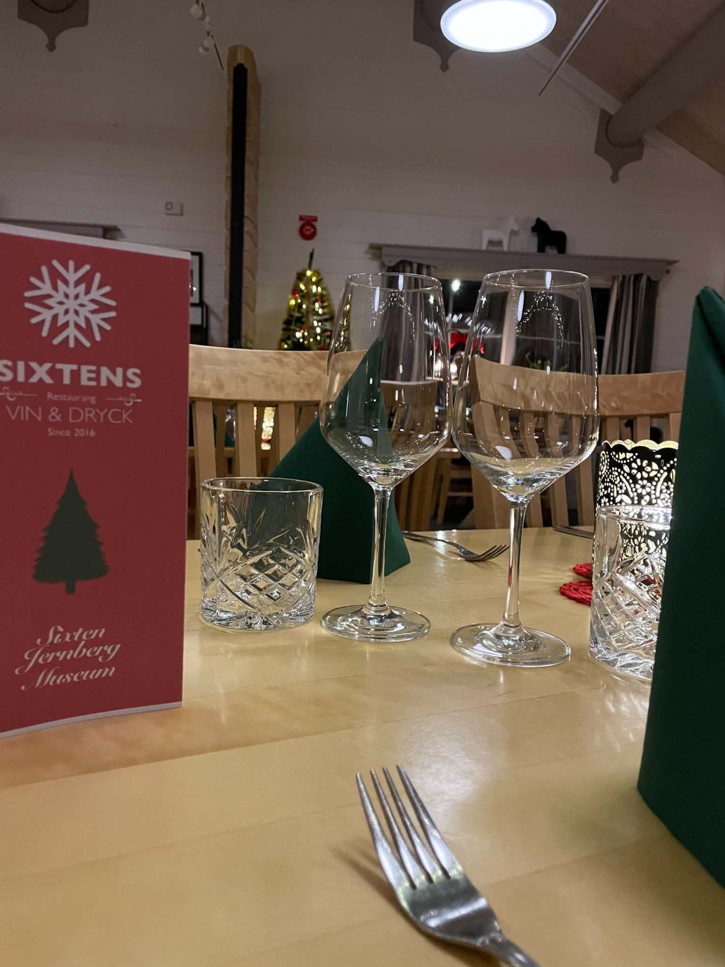 Dukat bord med gröna servetter, glas och ljus